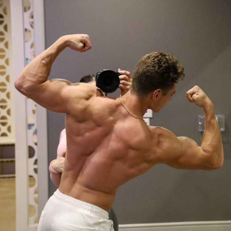 Colton Wergin showing off his muscular back in a back double biceps pose