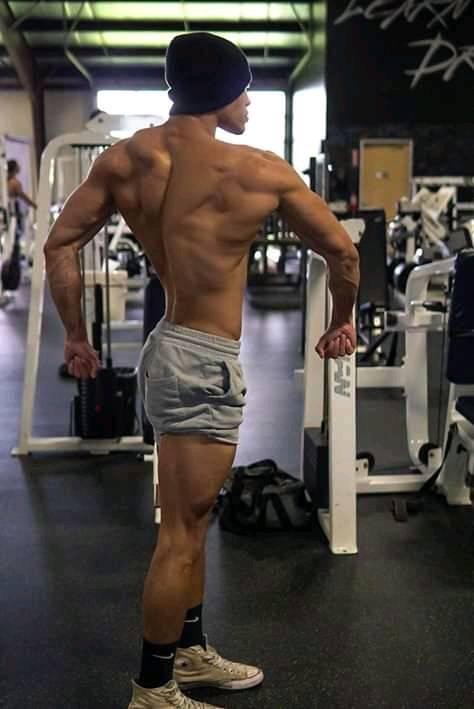 Devin Truss flexing his back muscles in a gym