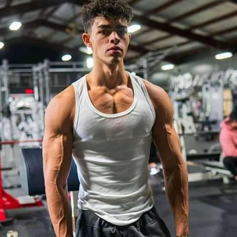 Devin Truss in a white tank top looking swole and ripped