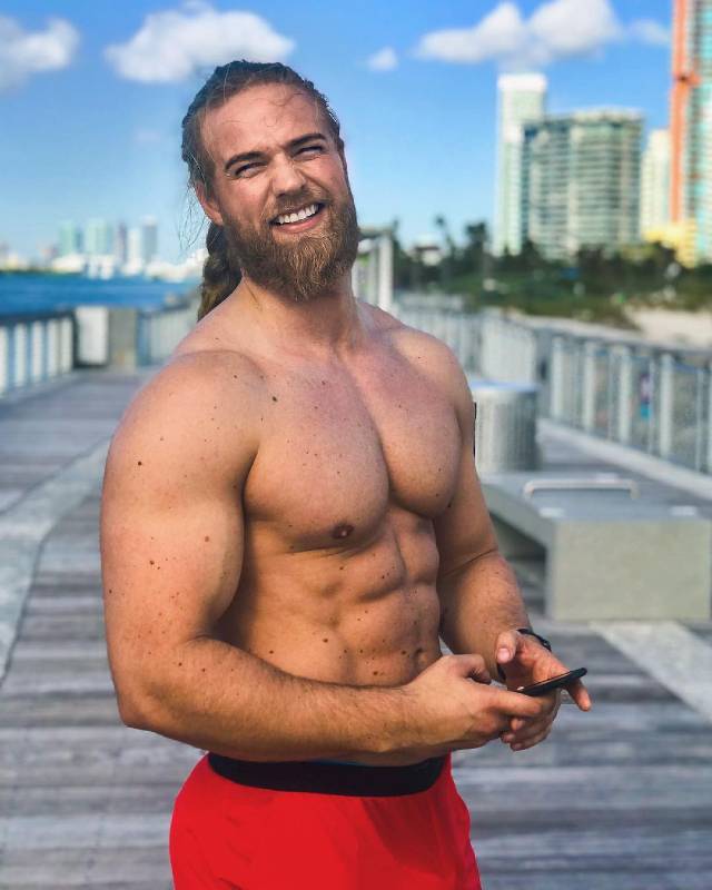 Shirtless Lasse Matberg standing on a pier and showing off his lean physique.