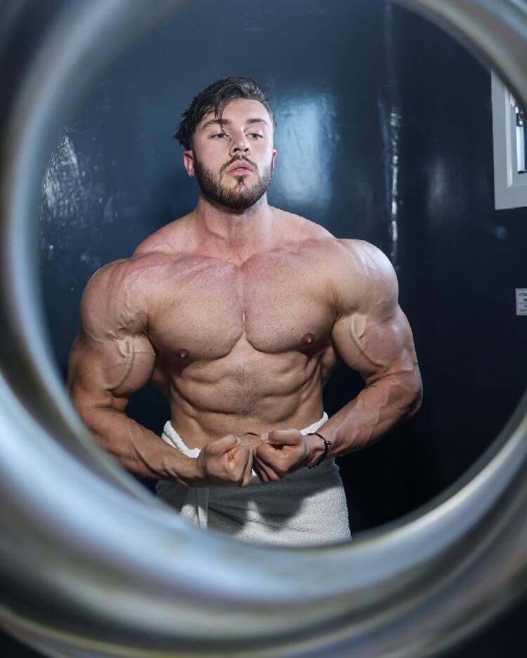 Brandon Harding flexing shirtless in front of a mirror.